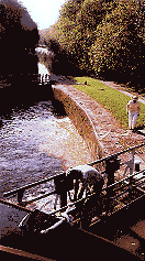 The lockmaster hand winds the gates and sluices on the canal.